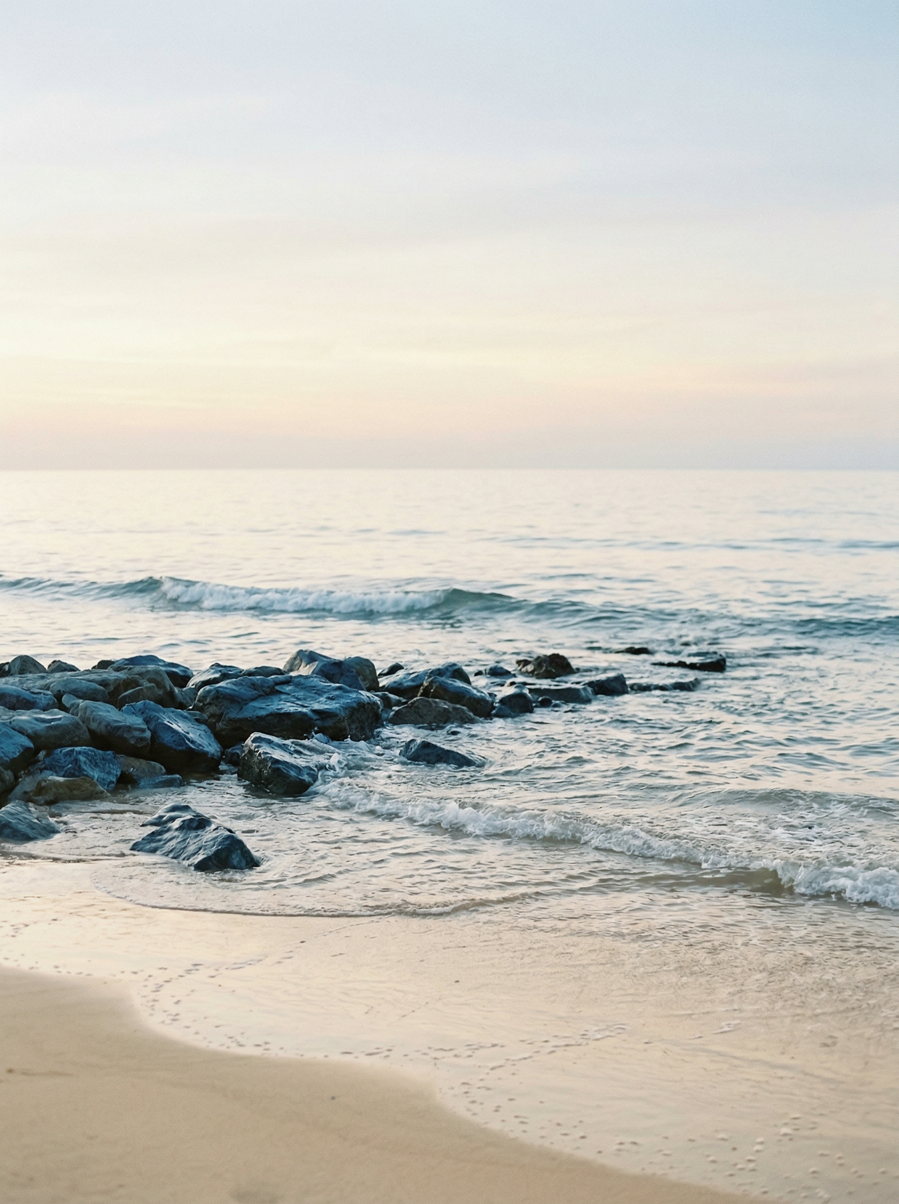 Strandfoto am Morgen mit Felsen im Sandstrand